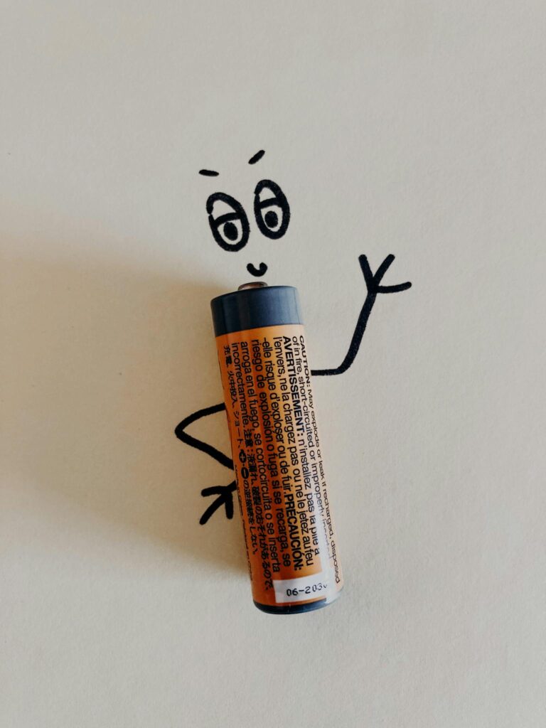 A AA battery creatively integrated into a hand-drawn doodle, giving it a lively expression and character.